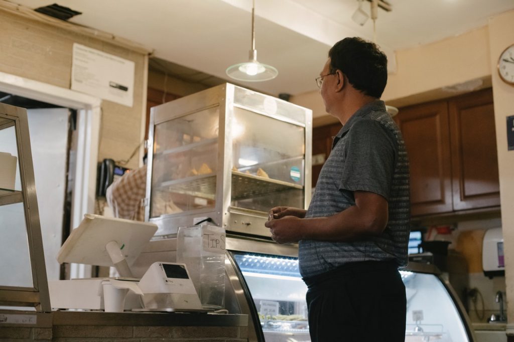 A man makes a retail purchase at a bakery.