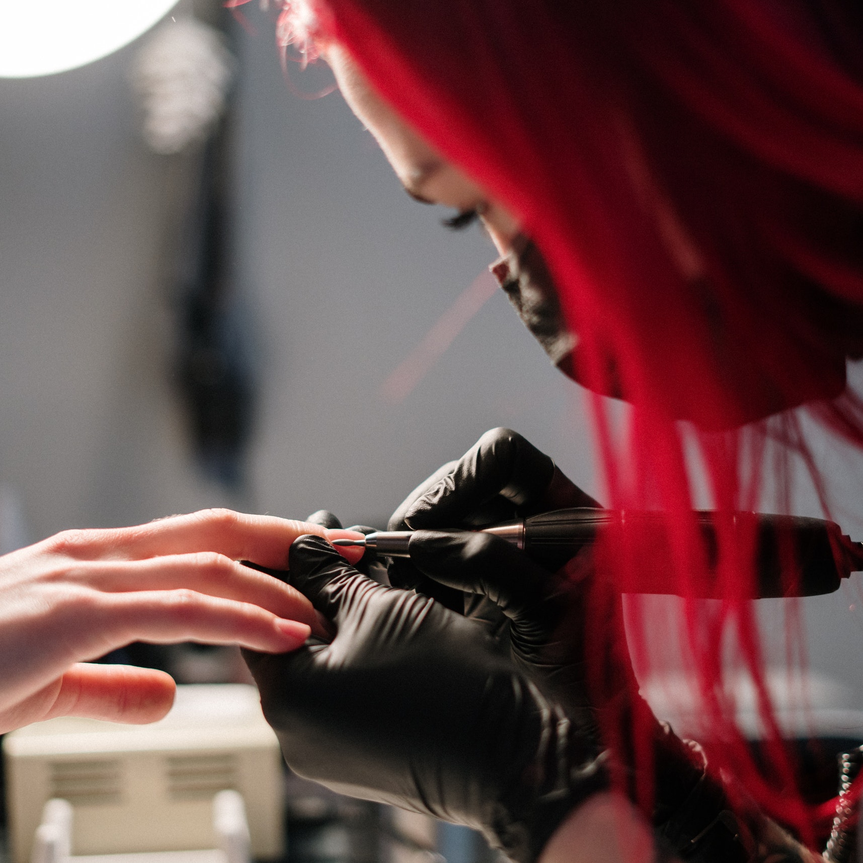 A close-up image of a worker and customer at a nail salon