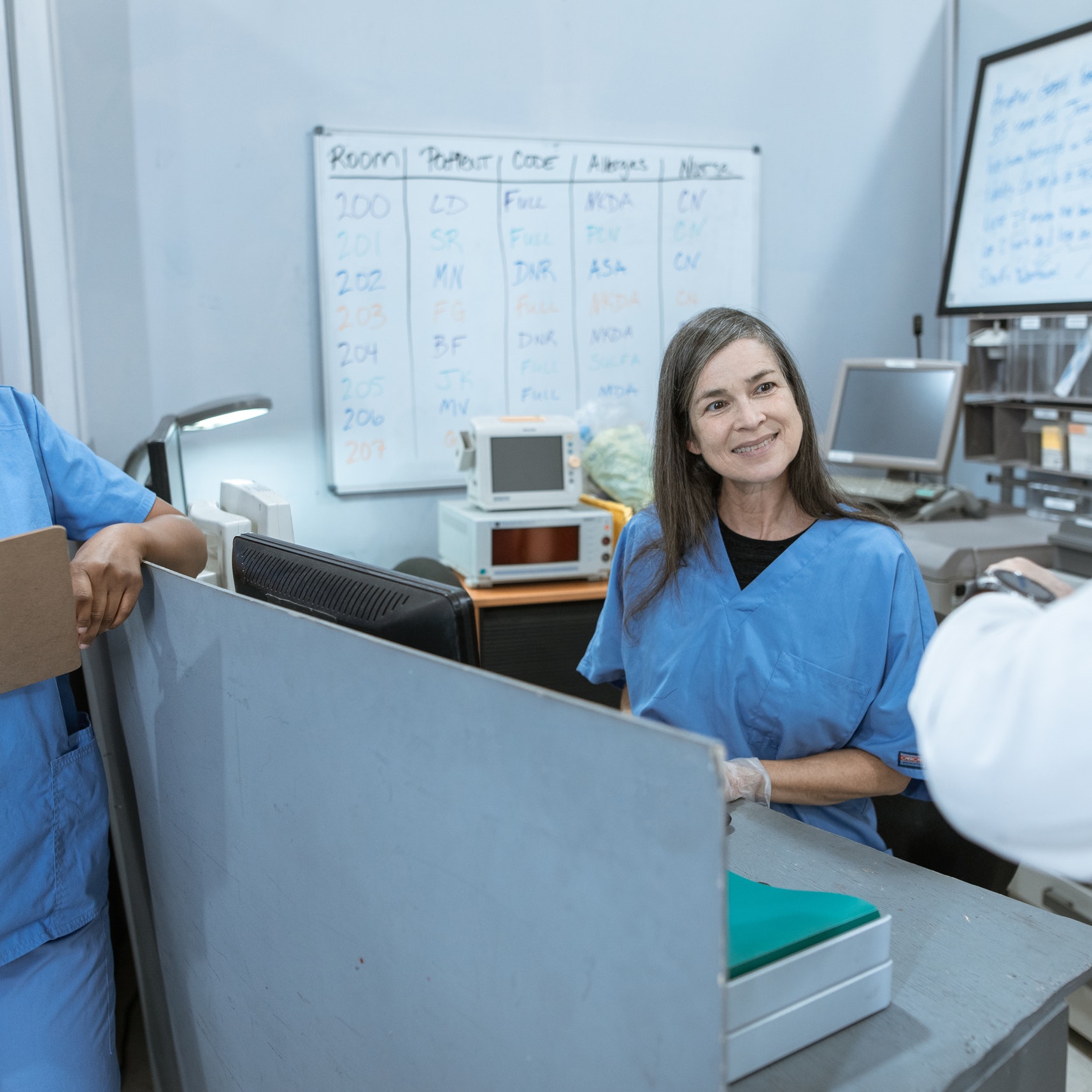 Nurses talk at a desk in a hospital