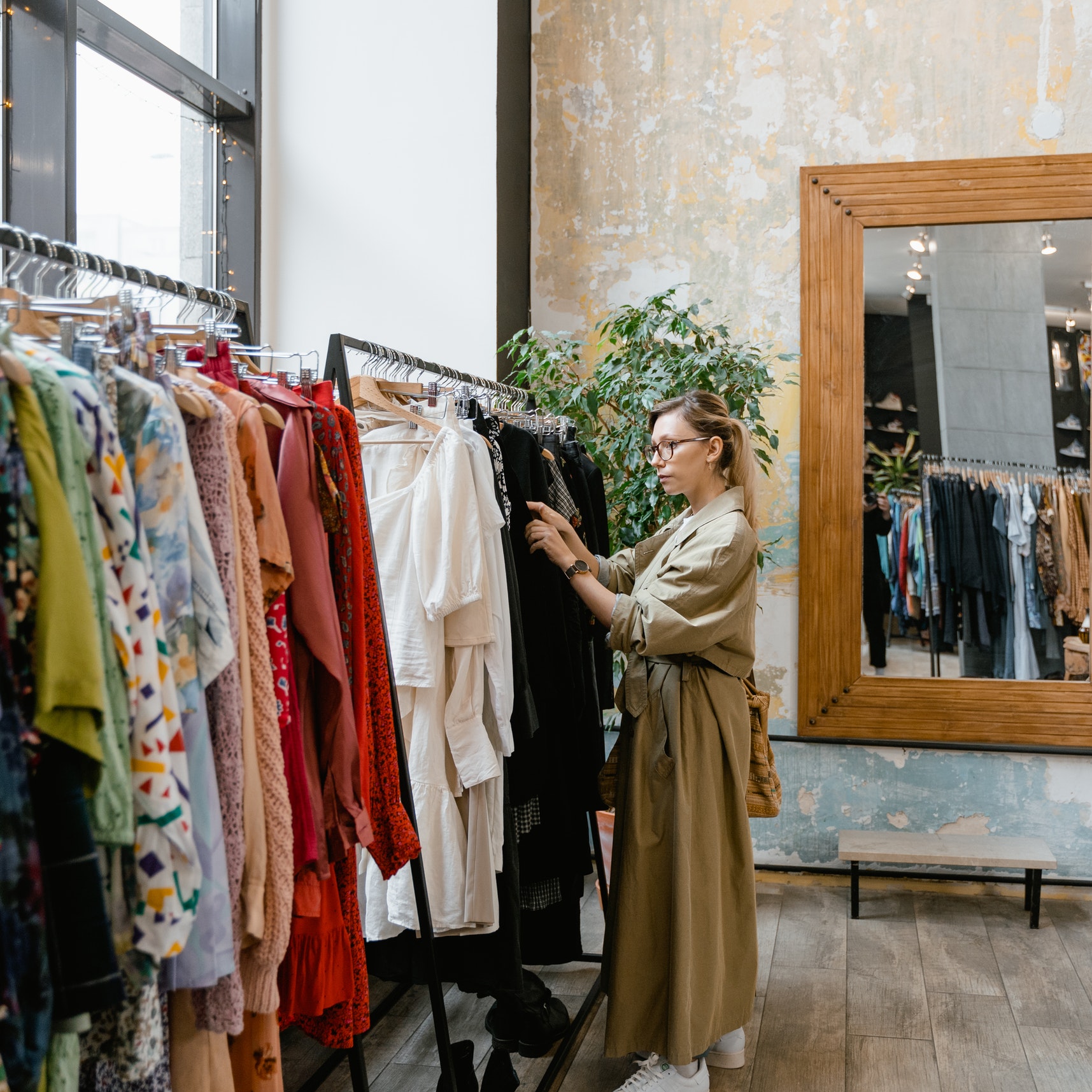 A woman browses a dress rack at a clothing store