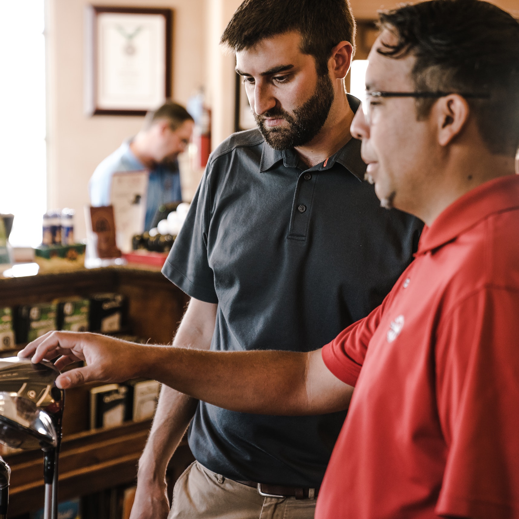 Two men standing near golf clubs