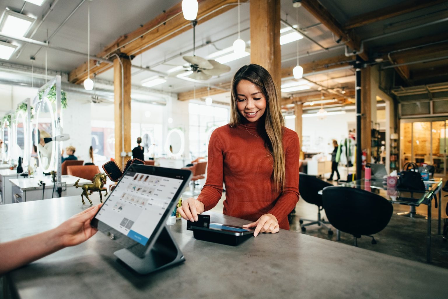 A point-of-sale system in front of a customer paying with a credit card