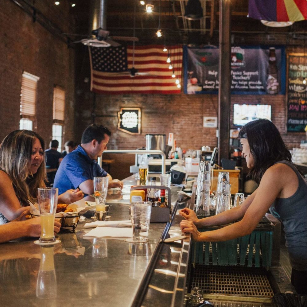 Woman serving customers at a pub bar counter