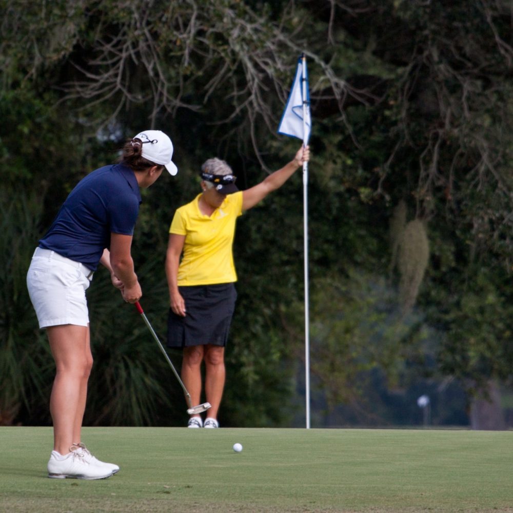 Two women playing golf