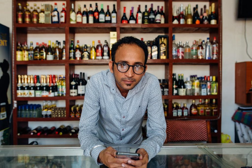 Liquor store owner preparing to accept credit card payments on a mobile device